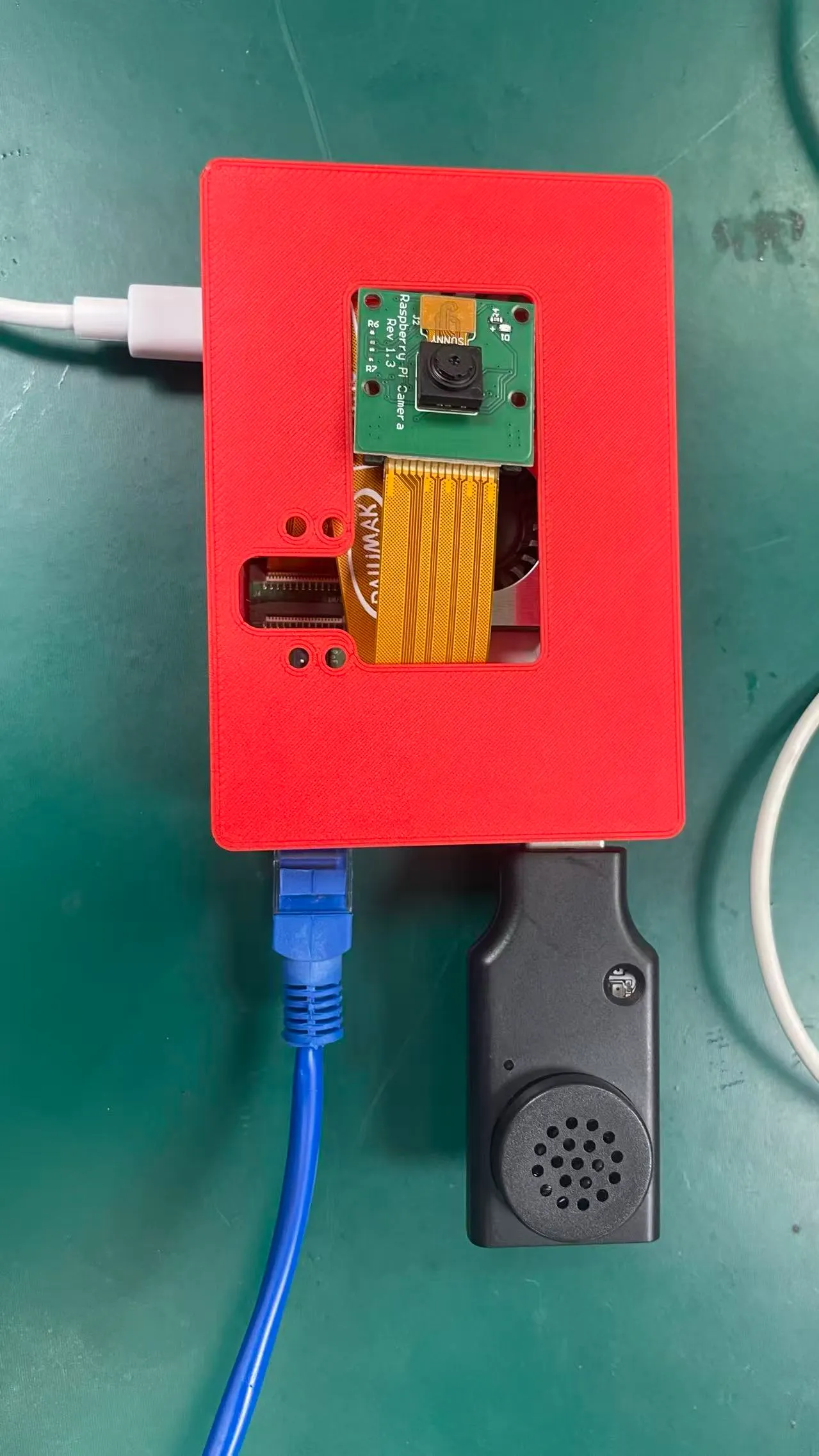 The three-part enclosure assembled. A front window exposes the Raspberry Pi Camera module, the ribbon cable folds back inside to the board, and the sides leave power and Ethernet accessible. The window position and cable bend radius were measured off the real board rather than modelled first and forced to fit.